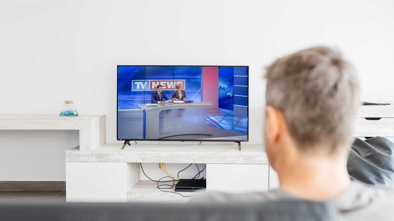 Man watching news program on TV